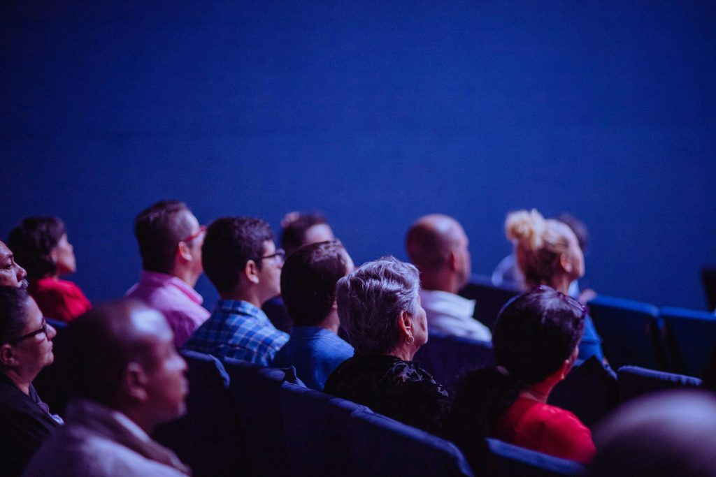 Ma’had Al-Jami’ah Akan Gelar Seminar Motivasi: “From FOMO to JOMO — Syukur di Tengah Comparison Culture” An attentive group of adults seated at an indoor conference, focusing on a presentation.